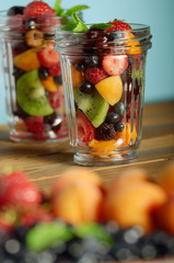 Assorted berries in mason jar on kitchen wooden table