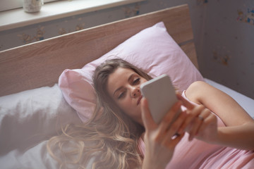 Obraz na płótnie Canvas Using phone in bed.