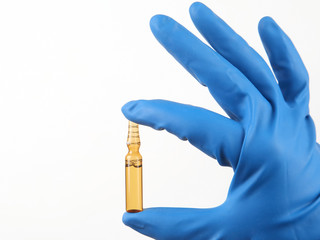 medical injection ampule in blue gloved hand