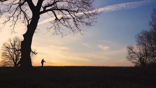 Grim Reaper came for a new victim and he follows the victim, the man, But the man runs away. sunset silhouette. concept of death and salvation