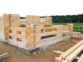 the beginning of the construction of a wooden house. The bar is profiled and falls into the groove. Laying in the corner. half laid and next still material