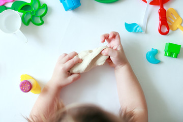 A Childs hands holding Play Dough. Concept of sensetive education and therapy of kids, top view