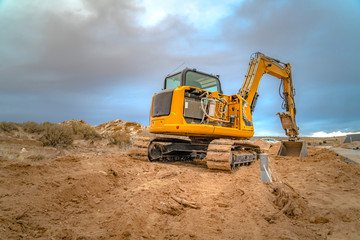 Obraz premium Excavator scooping and leaving tread marks on dirt