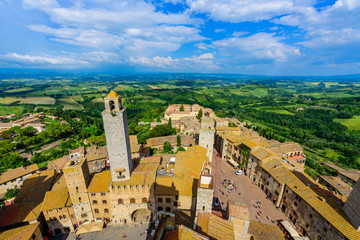 Naklejka premium San Gimignano - Aerial view of the historic town with beautiful landscape scenery on a sunny summer day in Tuscany, small walled medieval hill town with towers in the province of Siena, Italy