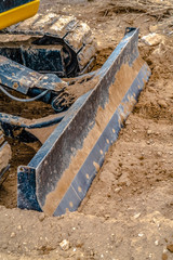 Excavator with grader blade attachment in Utah
