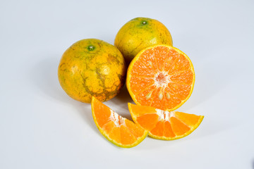 Half and slice of orange on white background.