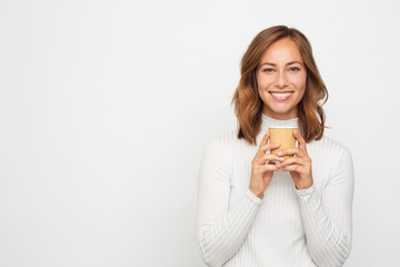 portrait of happy young woman with to go cup of coffee