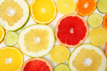 cut pieces of different citrus fruits on white background