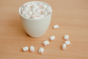Fototapeta na wymiar Marshmallow with white cup on table. 