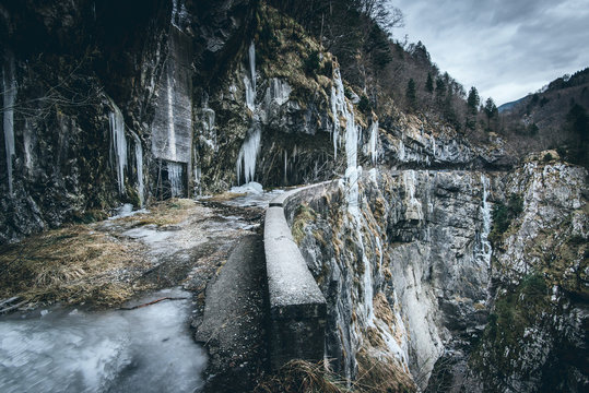 frosty canyon road in winter season - moody style image - Powered by Adobe