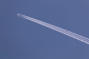The white airplane fly in the sky, jet engine make the white line of smoke in the blue sky, for...
