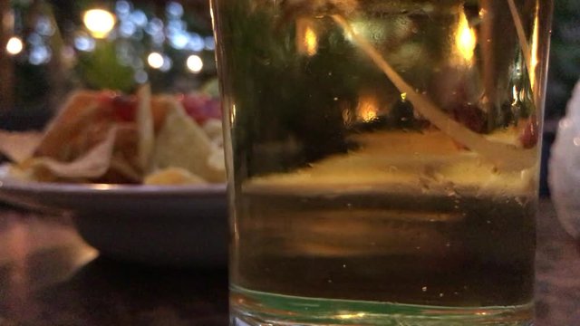 Glass of beer close up with bubbles in slow motion