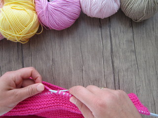  hands lady knitting in various colors.