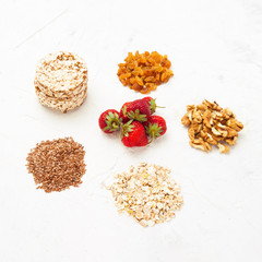 Natural sources of minerals. Oat flakes, flaxseeds, strawberries, rice loaves, walnuts and raisins. Concept of healthy eating.