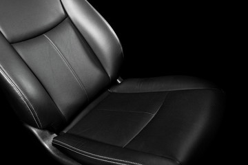 Black leather interior of the luxury modern car. Perforated Leather comfortable seats with yellow stitching isolated on black background. Modern car interior details. Car detailing. Car inside