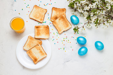 Easter Blue Eggs, Toasts and Orange Juice on the Light Background. Top View.