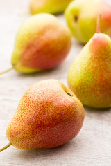 Fresh pears with leaves in a on wooden background.