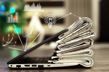 Newspapers and Laptop. Business Journals and Financial Magazines Stacked on Computer with Virtual Graphs and Charts. Concept for Connection of Media Content on Internet and Information on Paper Pages