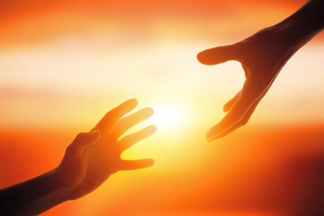 Giving a helping hand on the background of the dawn