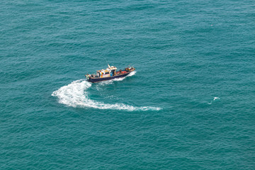 Fototapeta premium Small fishing motorboat boat turns