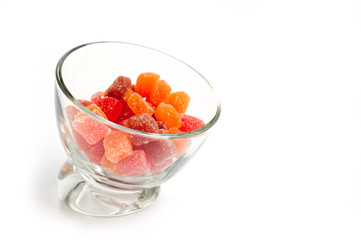 Jelly candies vitamins in a glass vase on a white background