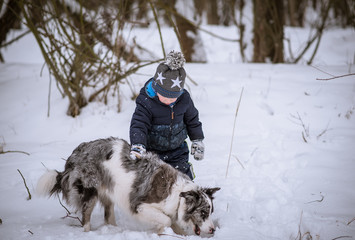 Young boy with his dog in winter park