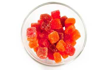 Jelly candies vitamins in a glass vase on a white background