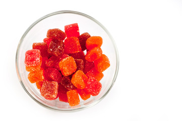 Jelly candies vitamins in a glass vase on a white background