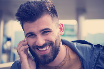 handsome young casual business man with beard using cell phone