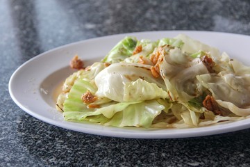 Closeup stir fried cabbage with dried shrimp in white dish thai style