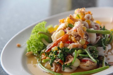 Spicy seafood salad mixed with vegetables, giant catfish roe, Thai herbs and boiled shrimp in Thai style