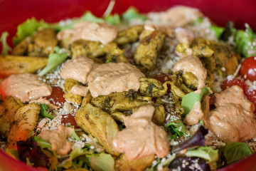 Macro shot of sunflower seeds, sesame, lin seeds on top of red cherry tomatoes next to parmesan cheese, lettuce, chicken. Freshly made caesar salads with dressing. Healthy vegetables, food in summer