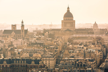 Fototapeta na wymiar Aerial view of Paris, France, with the imposing cupola of the Pantheon overlooking the residential buildings in a sunny and misty atmosphere.