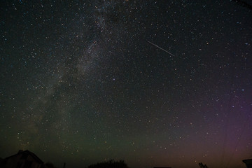 Abstract shot of starry sky. Stars are falling on clear blue nightsky. Shooting stars. Falling meteorite or comet with glowing light. Galaxy sky background. Perseid Meteor Shower