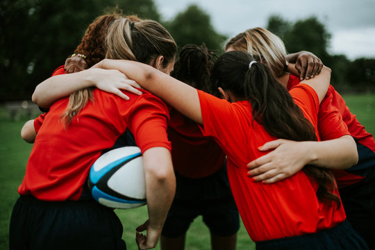 Young female rugby players huddling