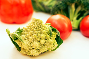 Ripe vegetables tomatoes romanesco broccoli on white wooden background with copy space for your text