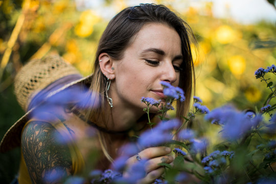 Woman smelling Vervain flowers in her garden