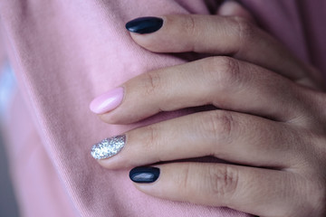 Gorgeous manicure, pastel tender pink color nail polish, closeup photo. Female hands over simple background