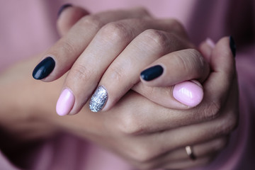 Gorgeous manicure, pastel tender pink color nail polish, closeup photo. Female hands over simple background