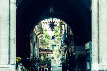 Arch, entrance of old houses, historical street of Catania, Sicily, Italy.