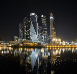 Moscow City skyscrapers at night with reflection in river
