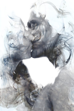 Double exposure of two blissful people close up embracing and becoming one with the smoky texture