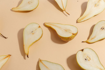 Composition of cut pears on a beige background. Top view.