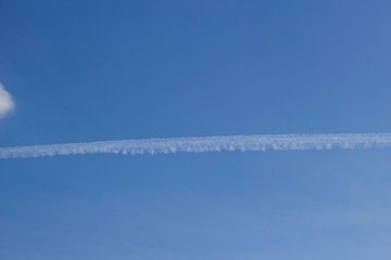 Trail of the plane in the sky. Blue sky