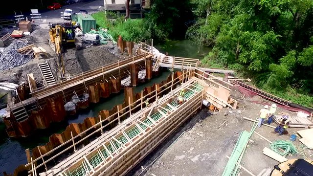 Aerial slow rise over bridge construction over Lititz Run Lancaster County Pennsylvania. Concept: renewal, building, men working, construction, public-private partnership, ?infrastructure