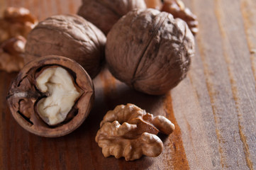 Fototapeta na wymiar Walnuts peeled and inshell. Brown wooden background. Healthy nutrition, health care, diet. Healthy, fresh and nutritious food. Close-up.