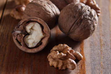 Walnuts peeled and inshell. Brown wooden table. Healthy nutrition, health care, diet. Healthy, fresh and nutritious food. Close-up.