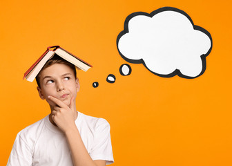 Boy with book on head thinking on orange background