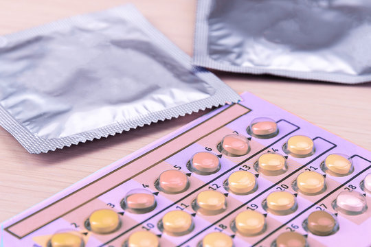 Birth control pills and condoms in package on light background.Concept of choosing method of contraception,safe sex nothing can happen.