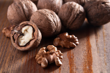 Walnuts peeled and inshell. Brown wooden background. Healthy nutrition, health care, diet. Healthy, fresh and nutritious food.